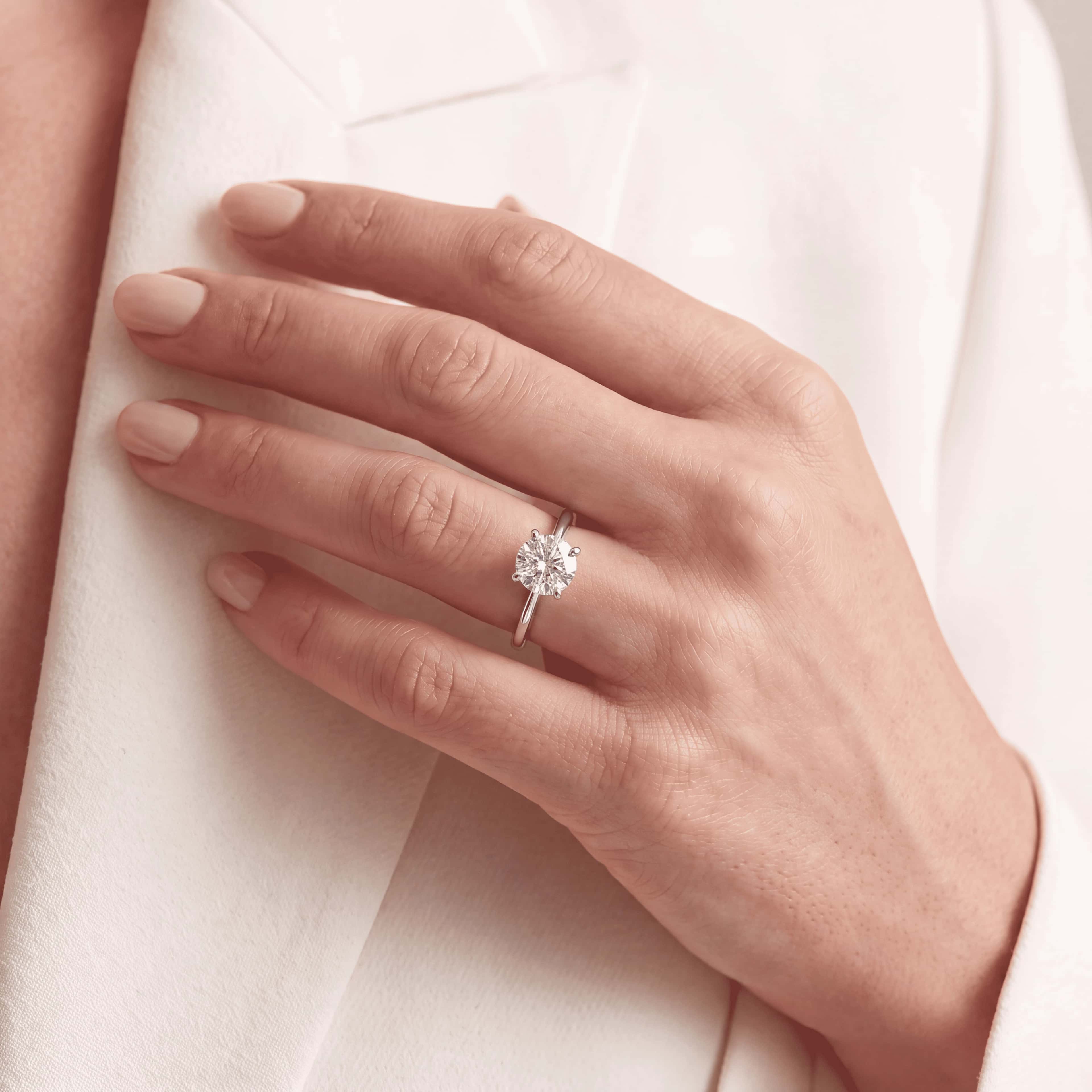 A round-cut diamond solitaire worn on the hand