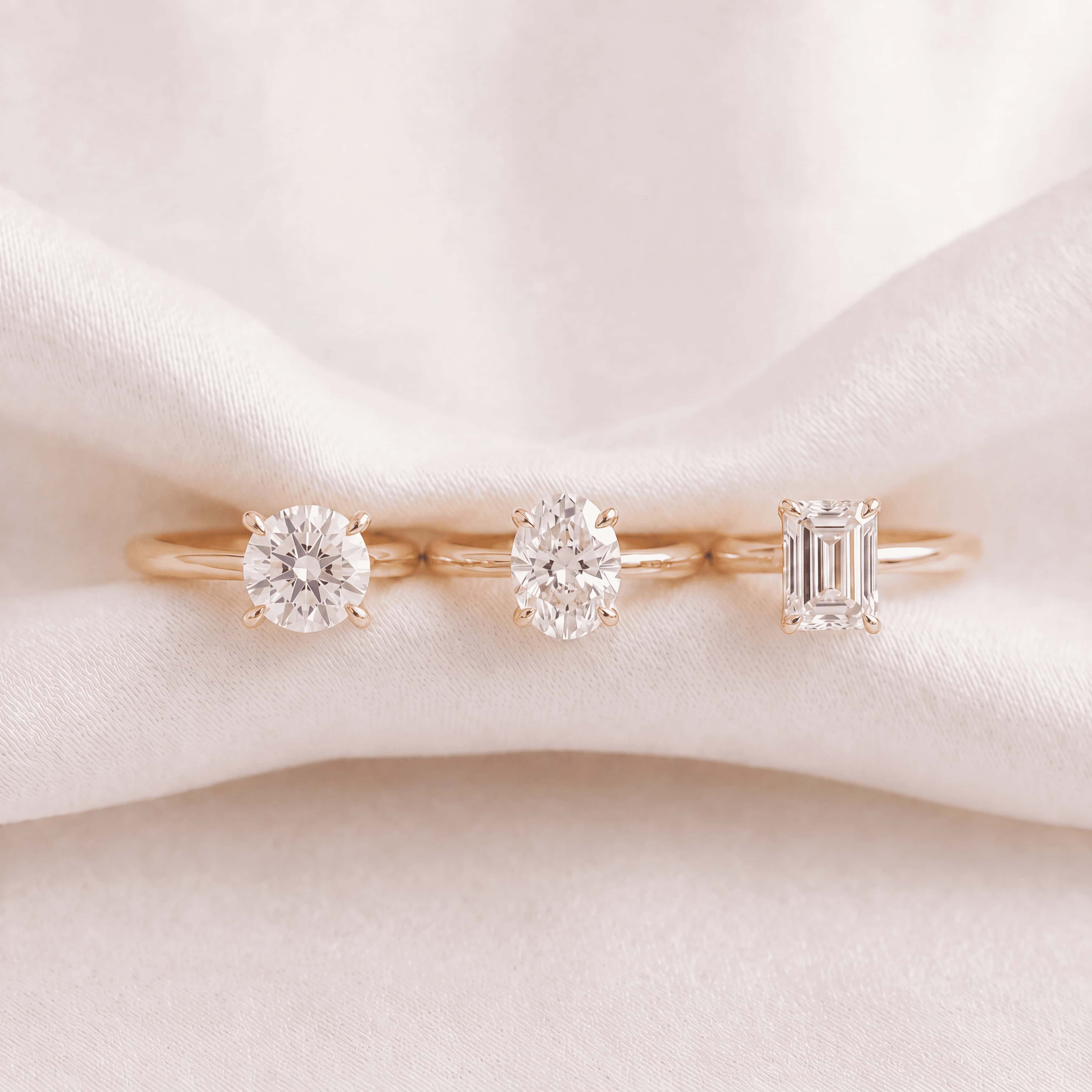 Round, oval and emerald-cut lab-grown diamond solitaires in rose gold on silk