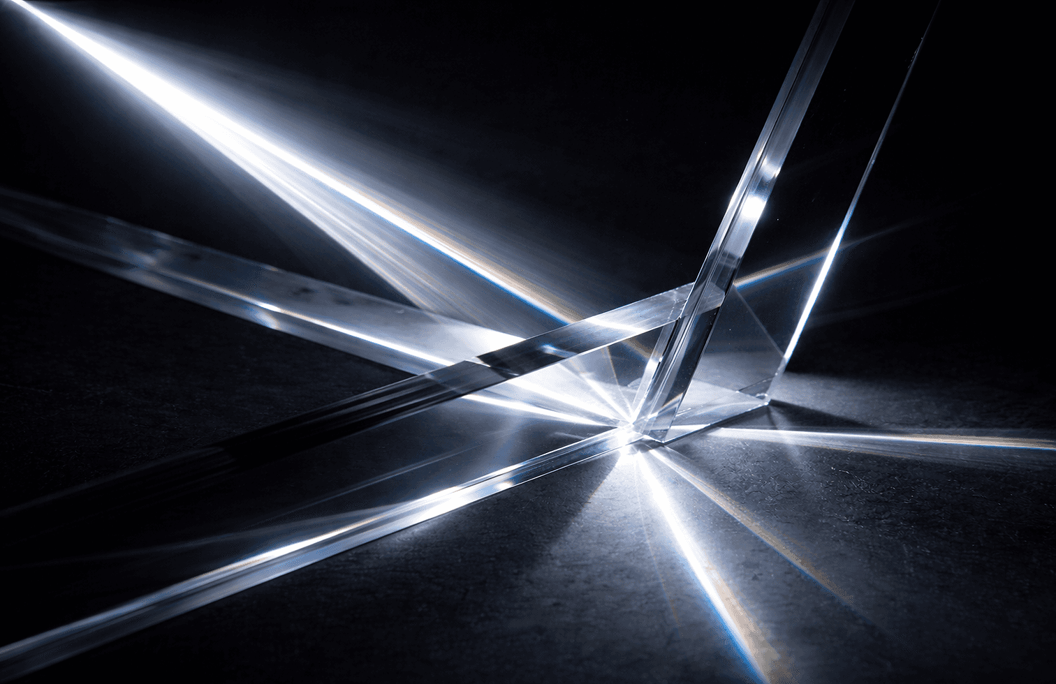A close-up of a prism with light shining through it, creating a spectrum of colors, representing the Lumen collection by MASAAT London.